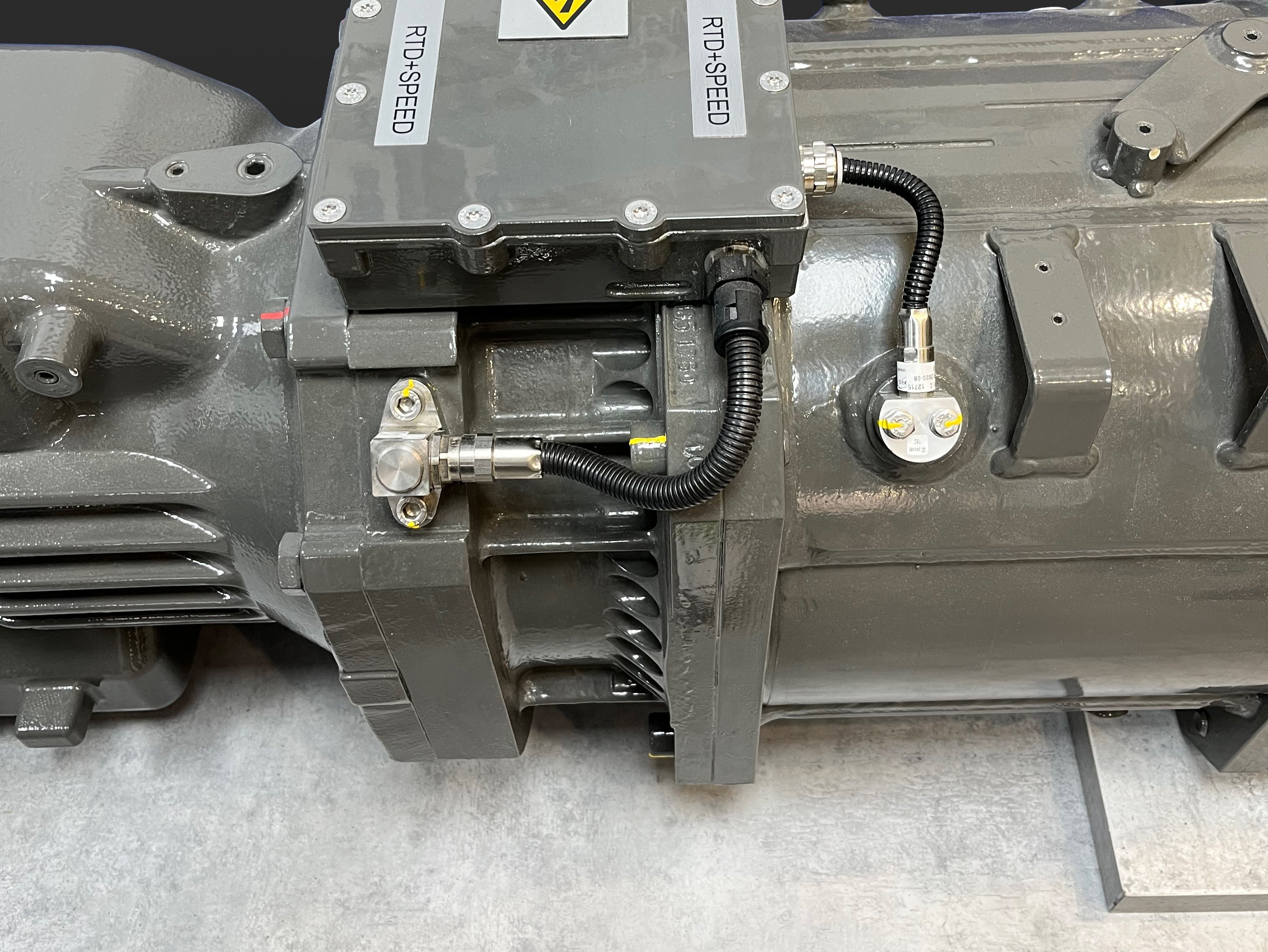 The image shows a traction motor of a railvehicle with a speed and a temperture sensor mounted on the motor.