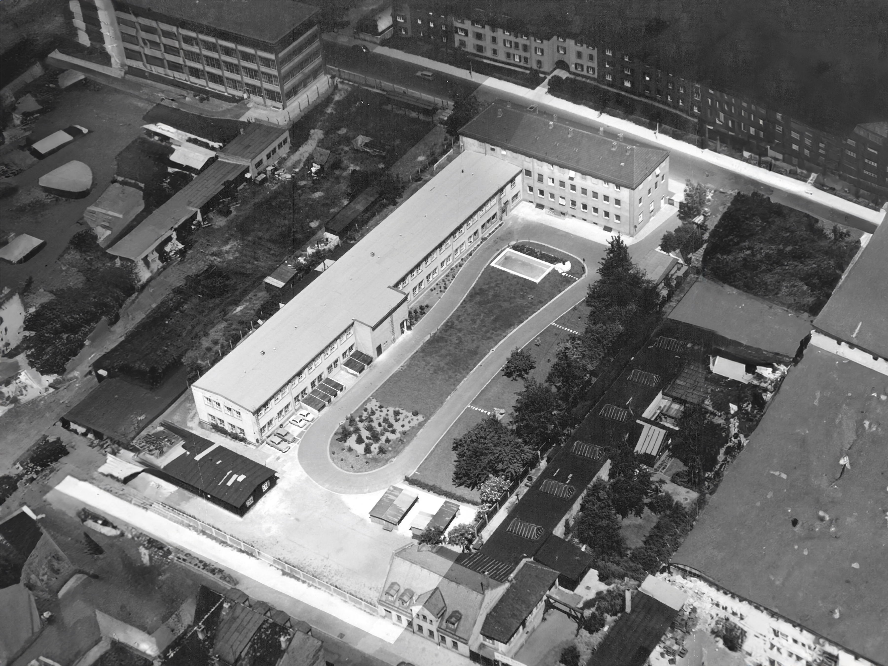 The image shows an old aerial photo of the company building of Noris Group GmbH