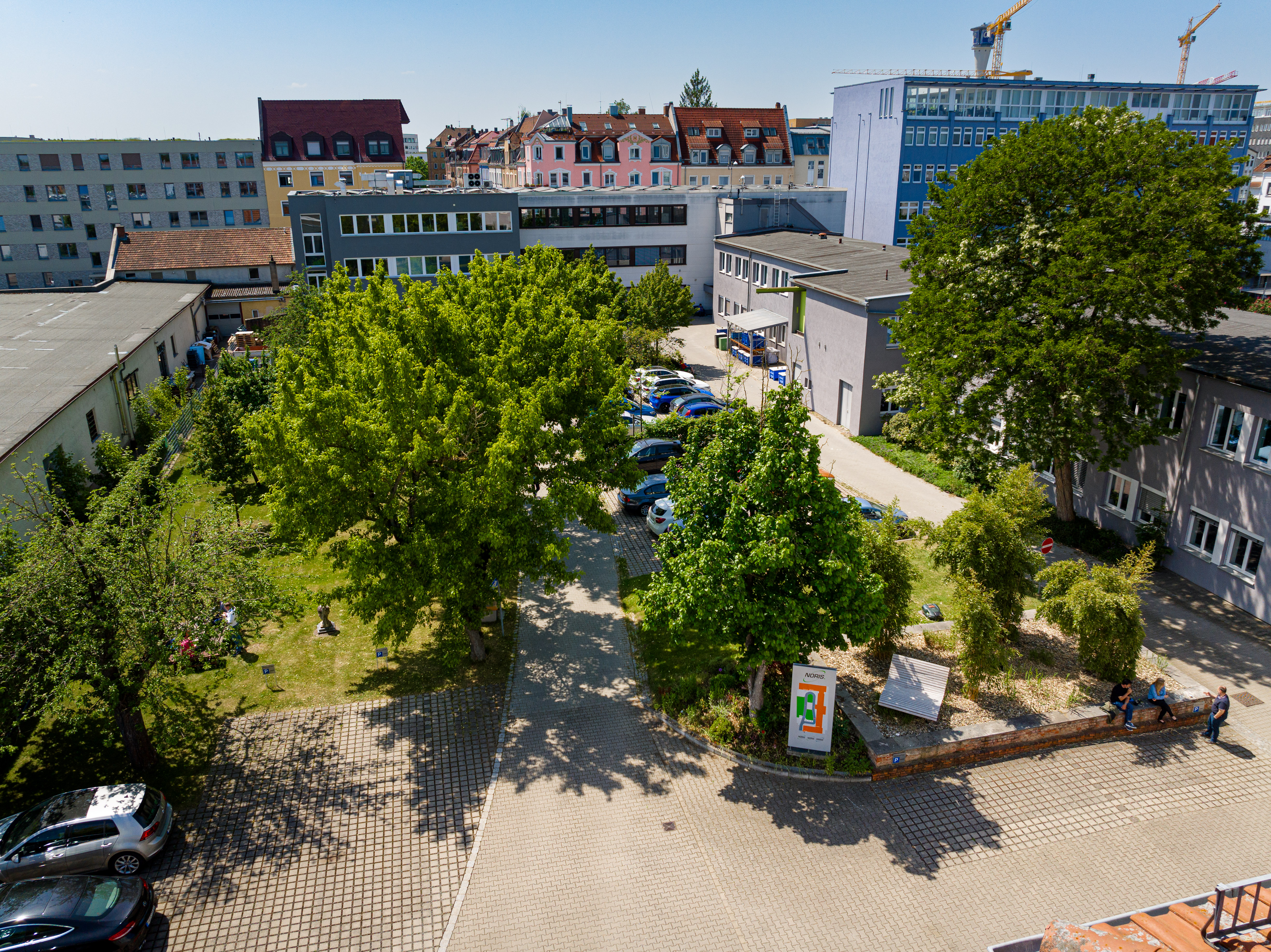 The image shows the Noris garden in the inner courtyard of Noris Group GmbH