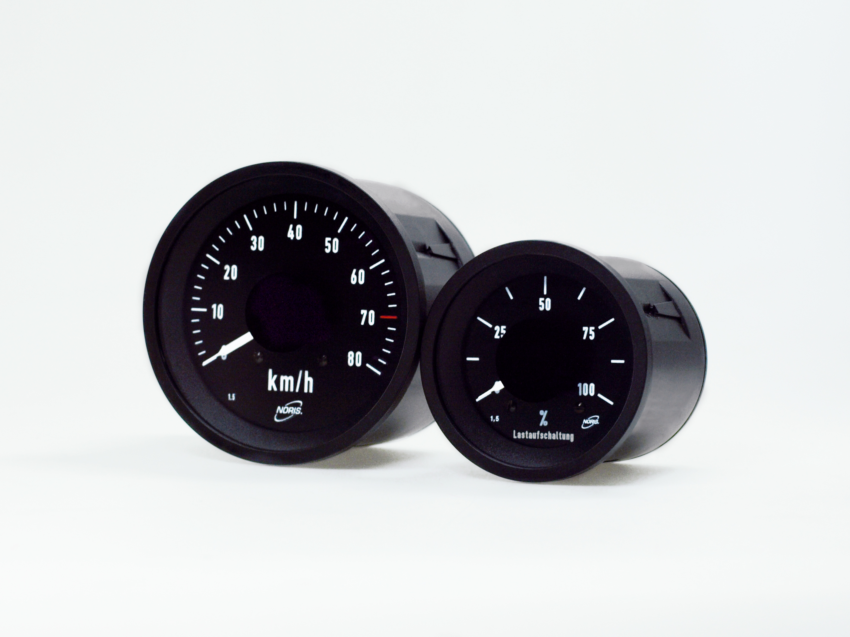 The image shows two round black analogue indicators with two different sizes arranged side by side