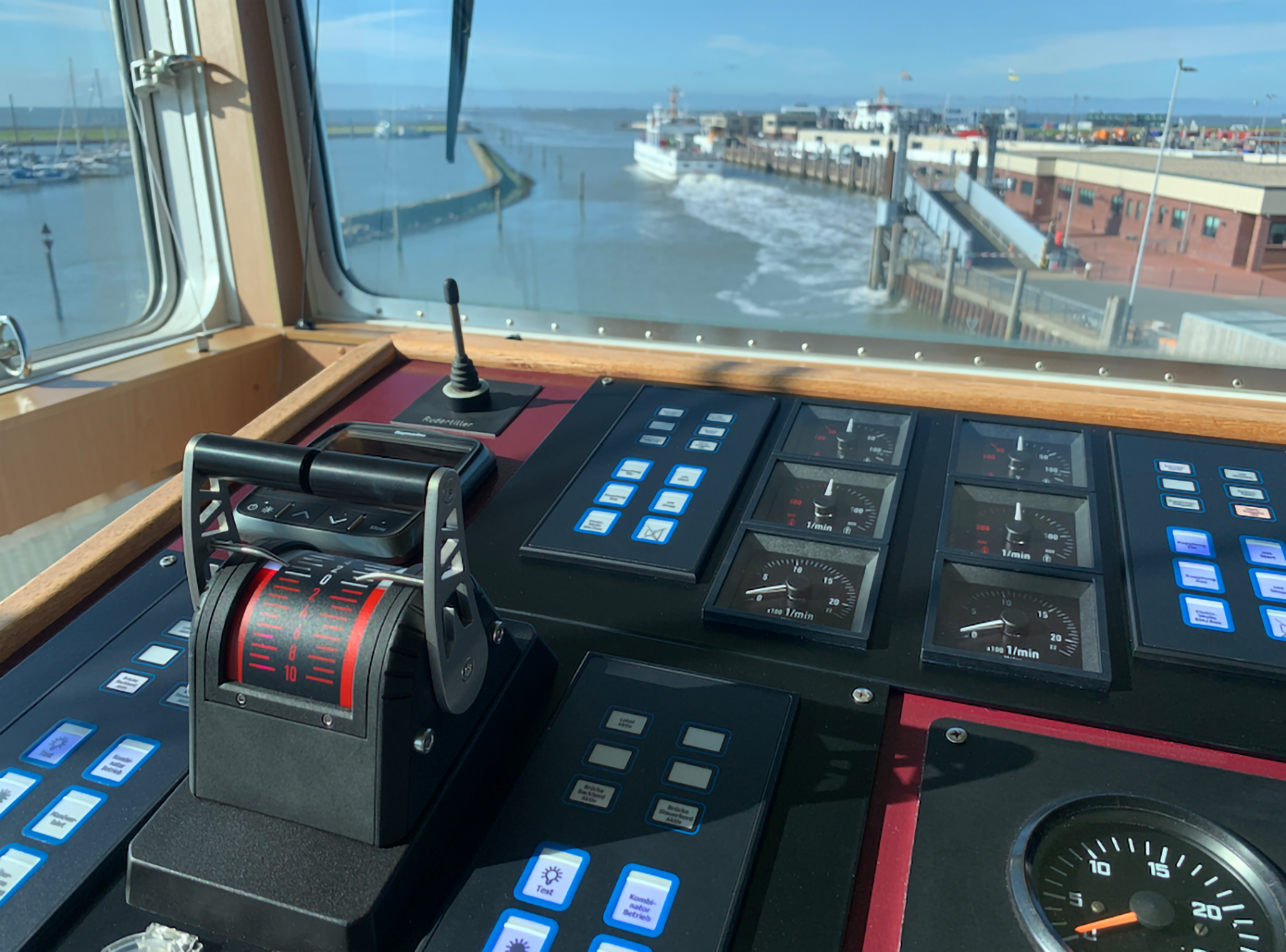The image shows a Bridge Panel with a NORISTAR remote control system. in the background the bridge window wiith the habour.