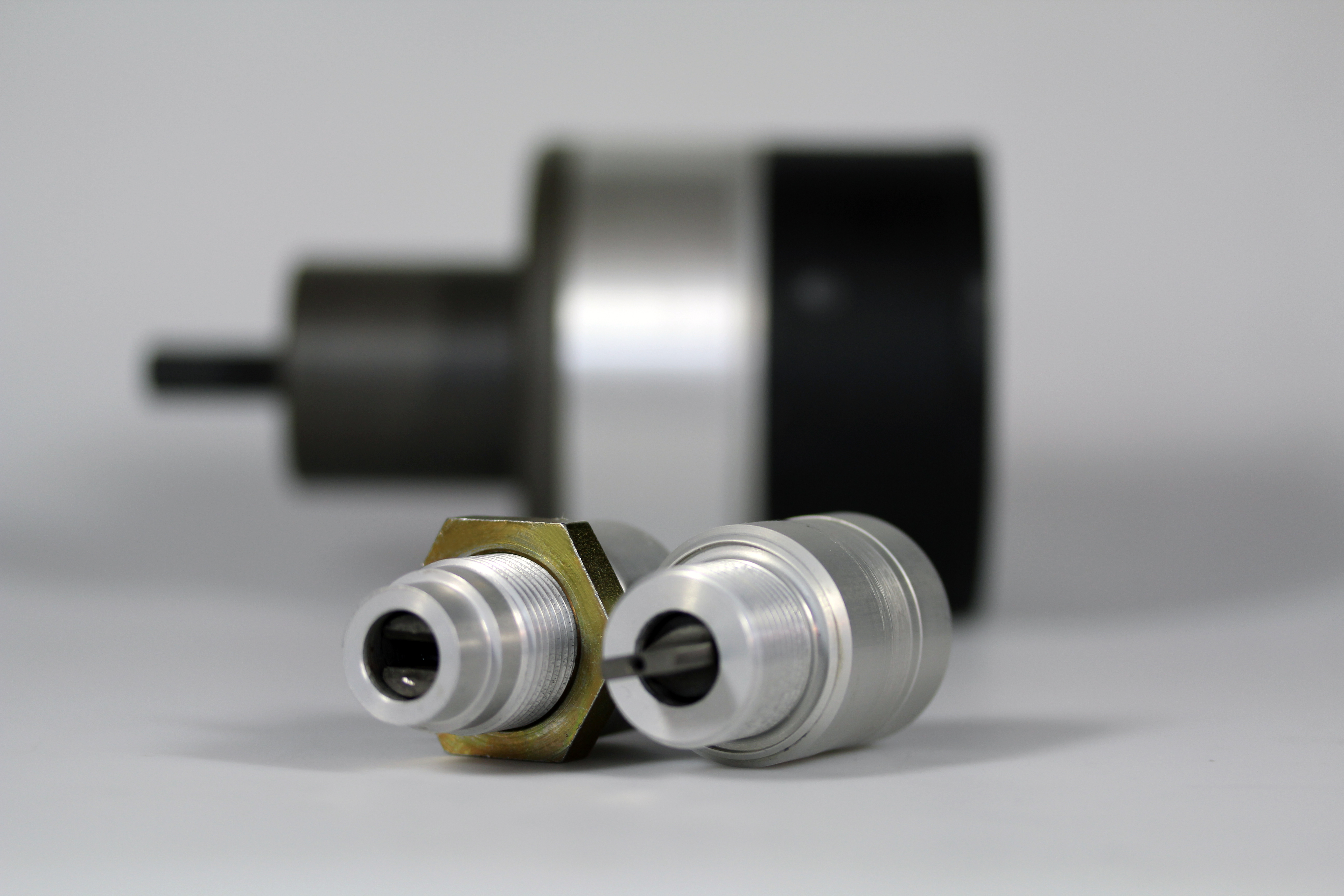 The image shows three mechanical connected spee encoder laying on a grey background
