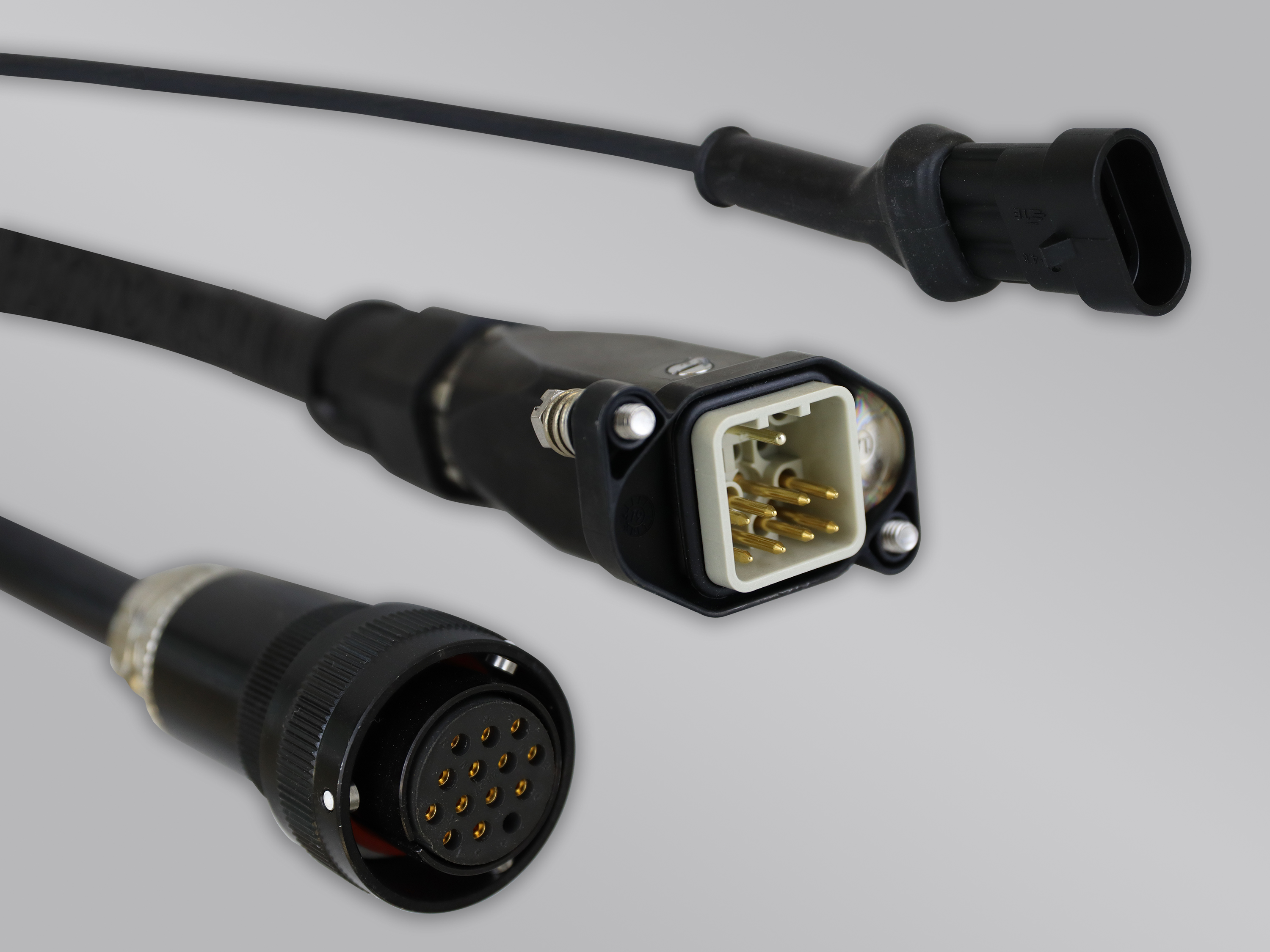 The image shows three different connector plugs on a grey background